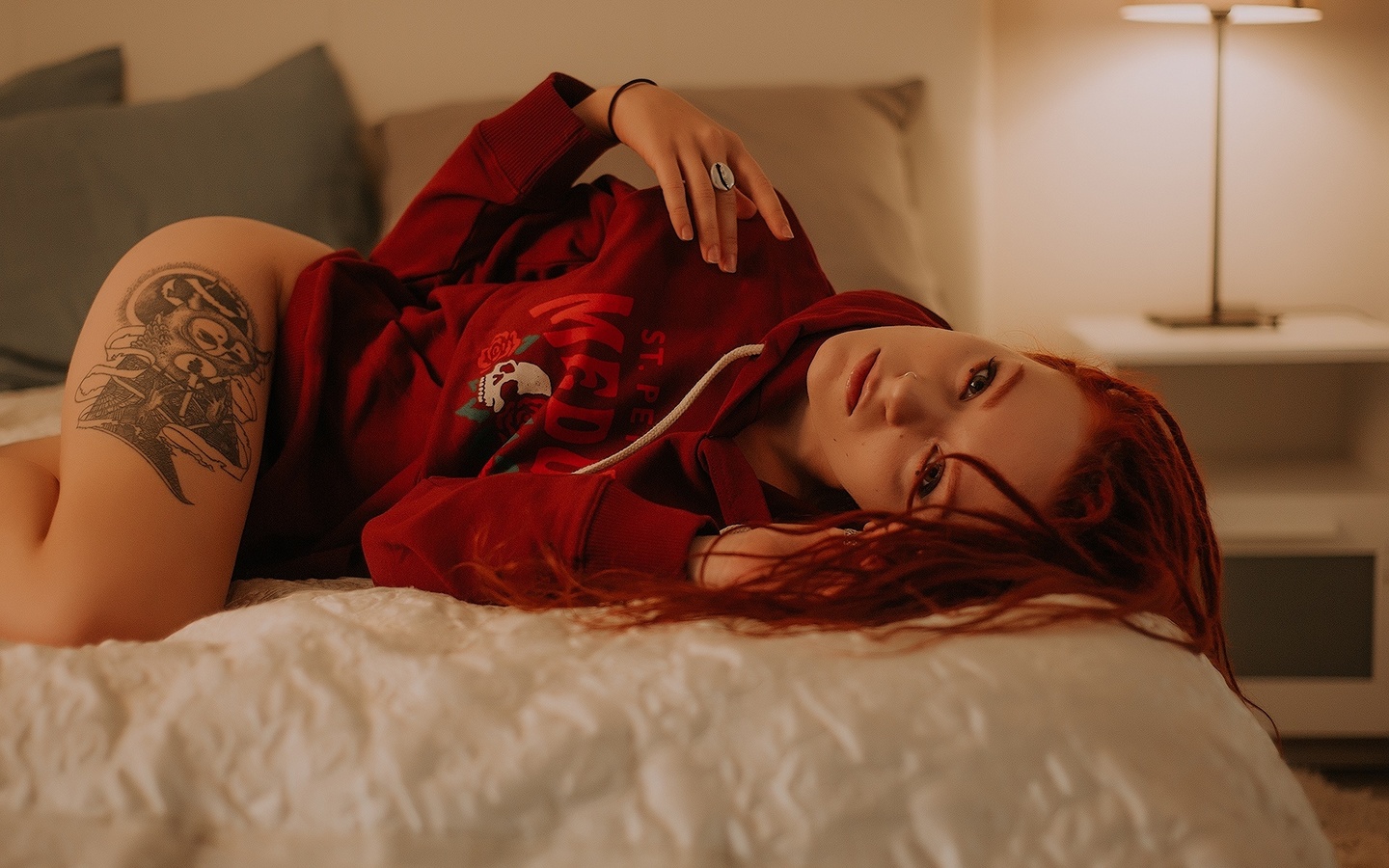 Татуированная негритянка с рыжими волосами раздевается на кровати