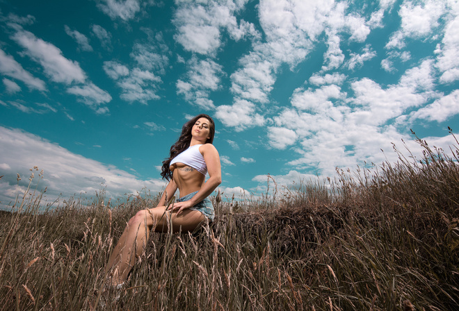 women, closed eyes, underboob, T-shirt, sitting, women outdoors, sky, clouds, tattoo, long hair, wavy hair, belly, brunette, boobs, jean shorts