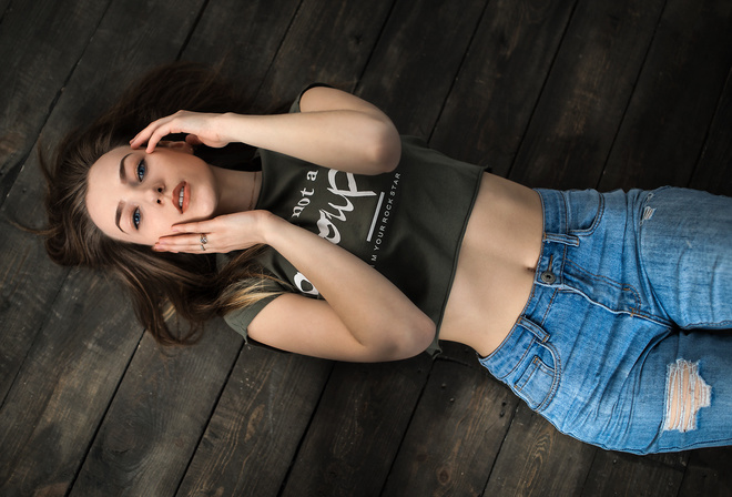 women, top view, brunette, torn jeans, blue eyes, lying on back, belly, wooden surface, portrait