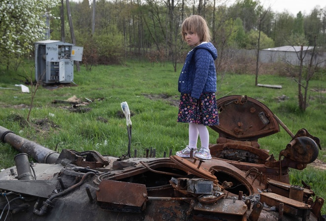 Makariv, Ukraine, girl stands on the tower of a destroyed Russian tank