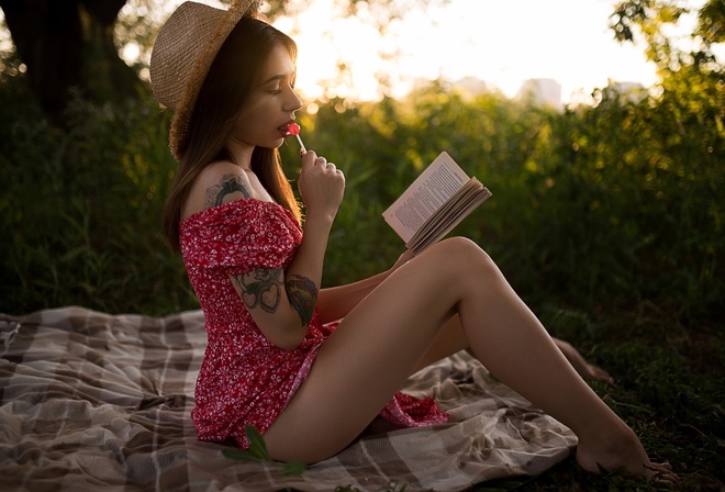 brunette, model, women, women outdoors, summer dress, tattoo, ass, picnic, straw hat, dress, barefoot, book, trees, grass, sunset, sitting, lollipop