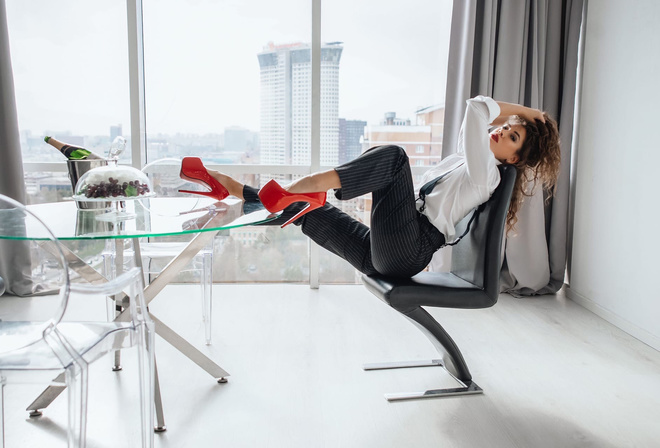 black pants, white shirt, red shoes, heeled shoes, high heels, window, women indoors, women, model, brunette, glass table, hips, sitting