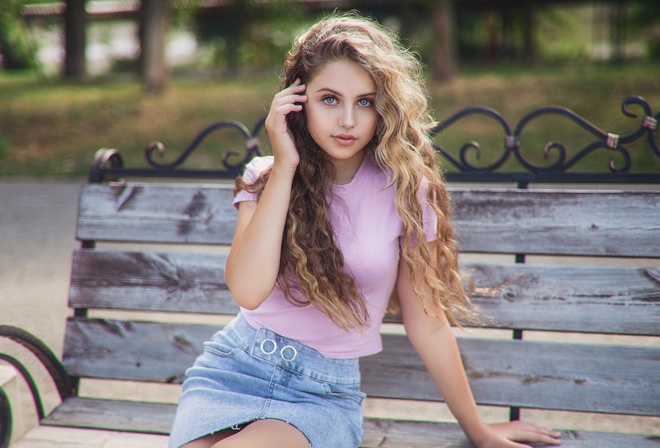 women outdoors, curly hair, denim skirt, T-shirt, park, garden, grass, trees, bench, women, model, blonde, looking at viewer, sitting