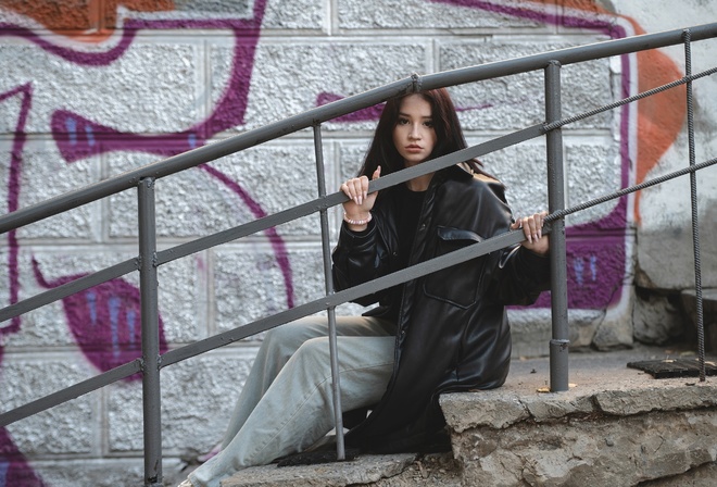 jeans, public, brunette, sitting, urban, , women outdoors, model, railing, trench coat, black jacket, graffiti, wall