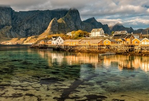 the sky, water, clouds, reflection, landscape, mountains, nature, rocks, shore, tops, the bottom, boats, Norway, houses, pond, the village, piles, The Lofoten Islands