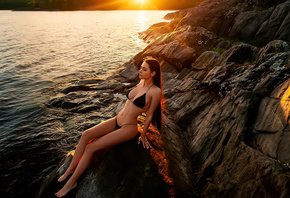 women, Helga Lovekaty, black bikini, sitting, long hair, brunette, rocks, water, sunset, belly, looking away, women outdoors