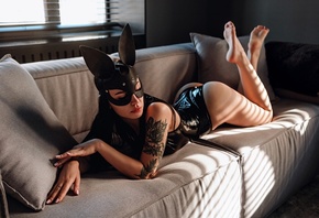 women, mask, black latex, women indoors, tattoo, ass, window, red lipstick, arched back, couch, blinds, feet in the air, bottom up, pink nails, bodysuit