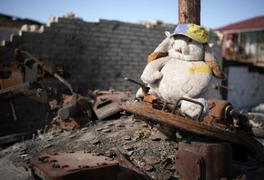 destroyed Russian main battle tank, childrens cuddly toy, war-damaged homes ...