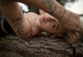 Alexander Nesterenko, tattoo, black top, blonde, nature, women outdoors, , trees, lying on back, model, tree trunk, sky, looking at viewer, clouds