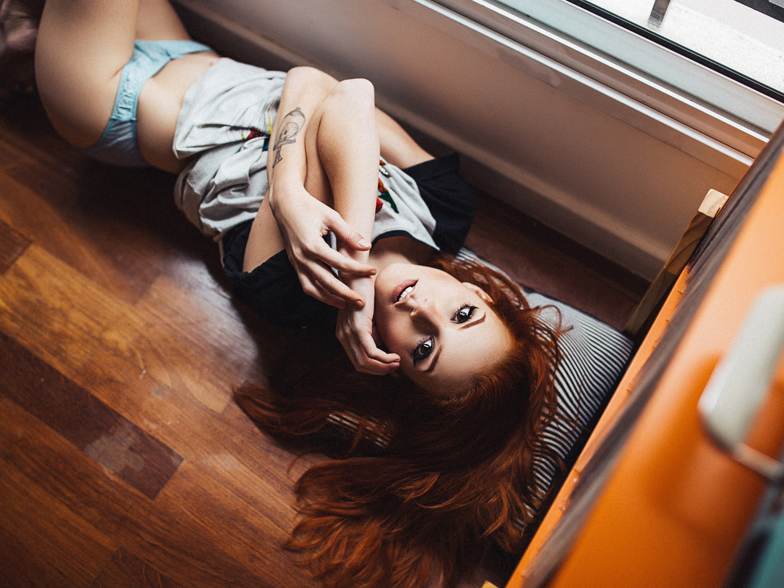 elisa rios, women, redhead, lingerie, thong, wooden surfac, eon the floor, looking at viewer, brunette, tattoo, henrique cesar, t-shirt