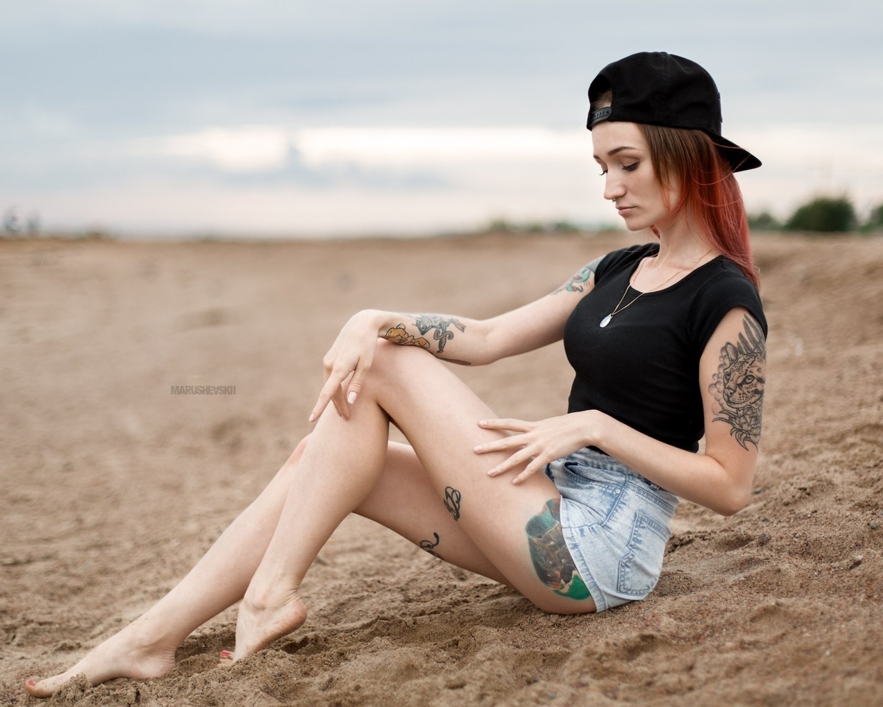 julia tyki, women, skinny, baseball caps, sitting, dyed hair, jean shorts, sand, nose rings, necklace, depth of field, tattoos