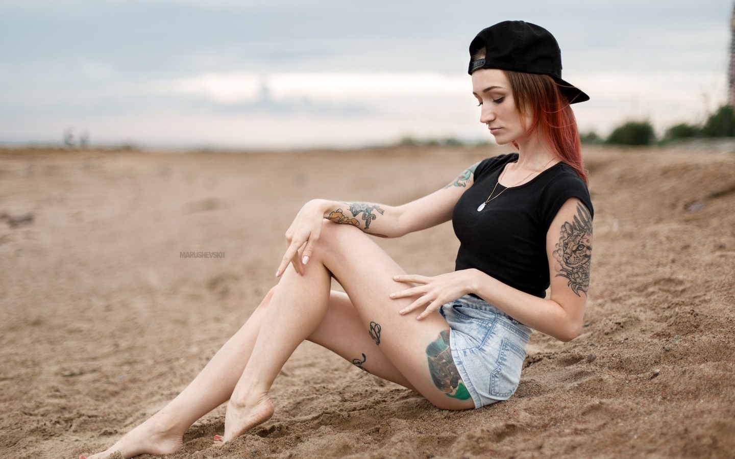 julia tyki, women, skinny, baseball caps, sitting, dyed hair, jean shorts, sand, nose rings, necklace, depth of field, tattoos