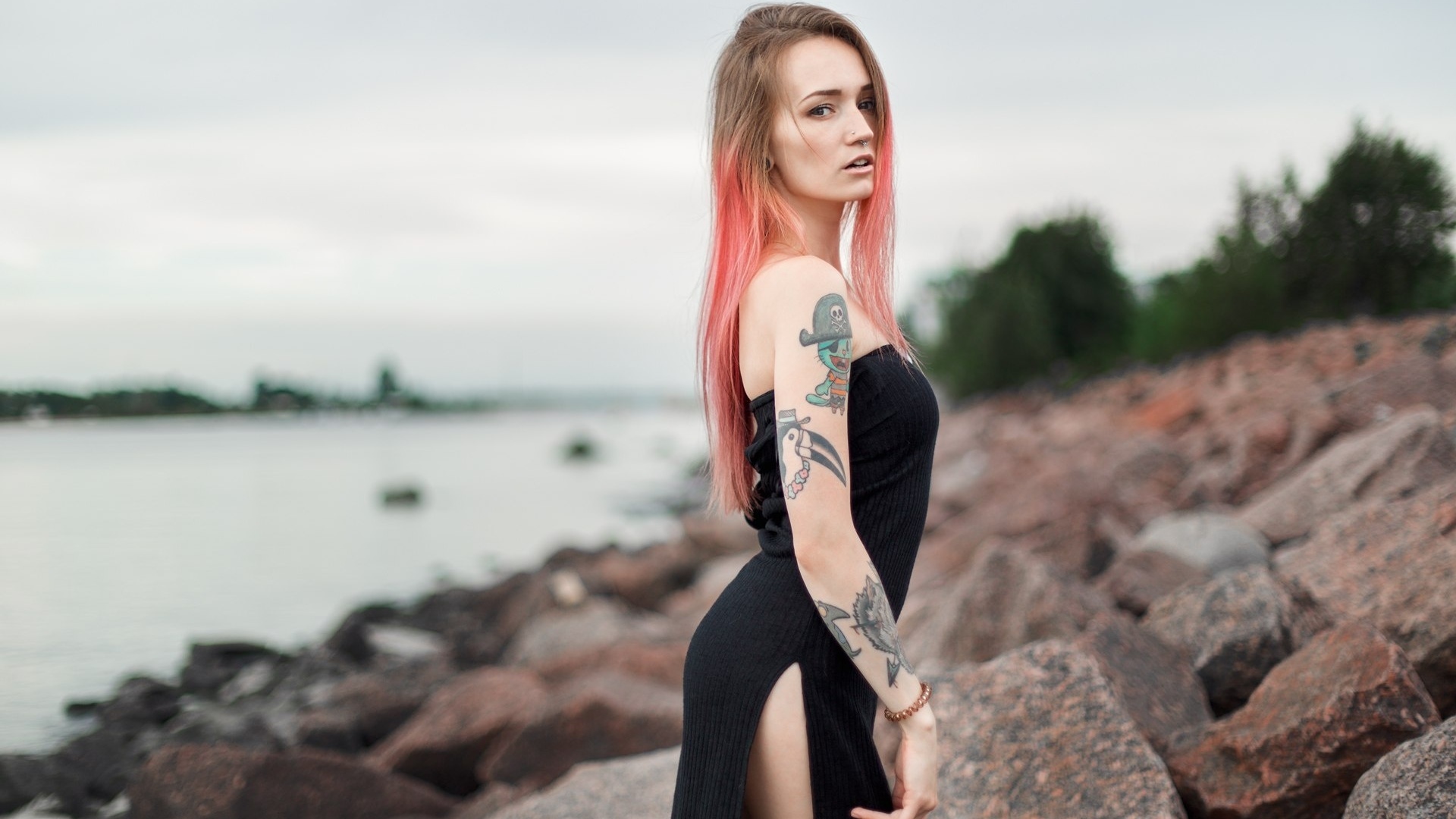 julia tyki, women, skinny, black dress, dyed hair, rocks, sea, tattoos, portrait, nose rings, pierced nose, looking at viewer, long hair, depth of field