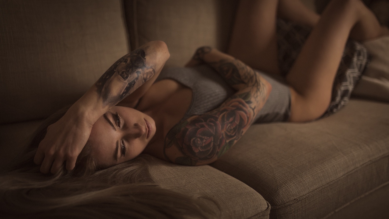 women, blonde, tattoo, hands on head, leotard, couch, lying on back, tanned