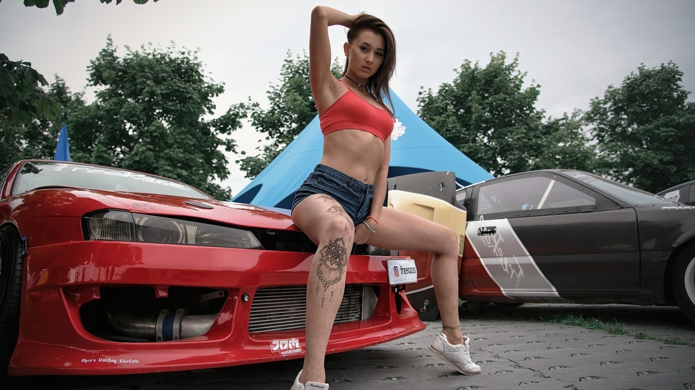 women, tanned, jean shorts, red tops, tattoo, car, women outdoors, sneakers, sitting, pierced navel, armpits