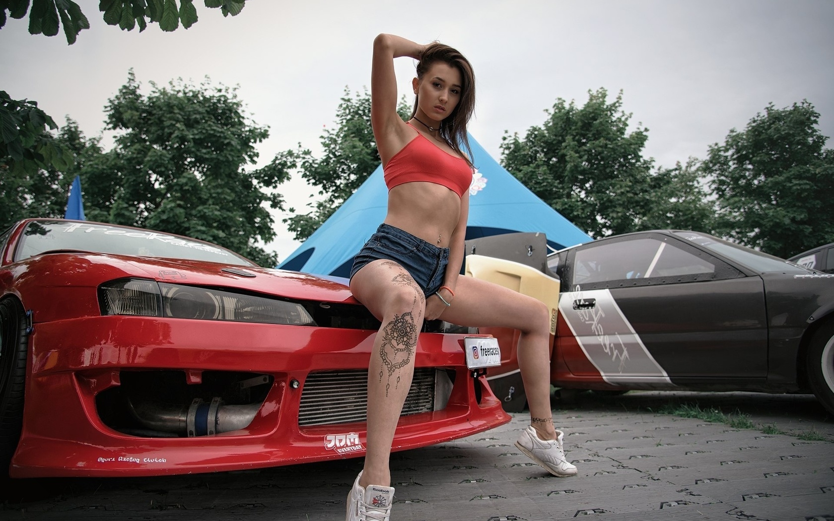 women, tanned, jean shorts, red tops, tattoo, car, women outdoors, sneakers, sitting, pierced navel, armpits