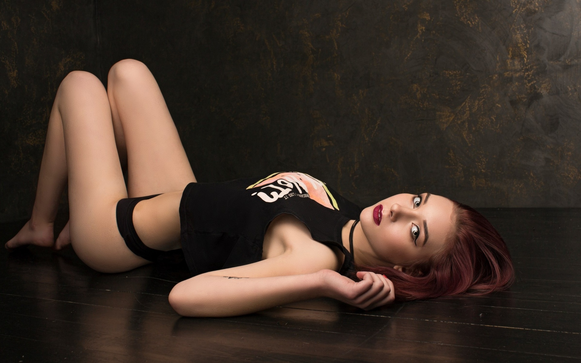 women, lying on back, black panties, t-shirt, wooden surface, looking at viewer, brunette, dyed hair, eyeliner