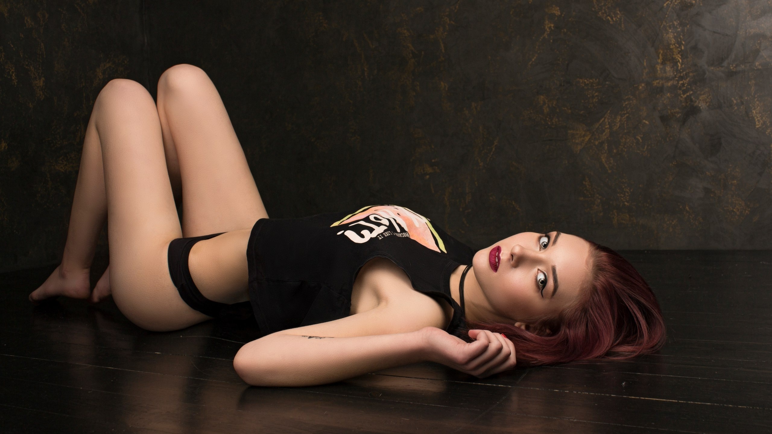 women, lying on back, black panties, t-shirt, wooden surface, looking at viewer, brunette, dyed hair, eyeliner