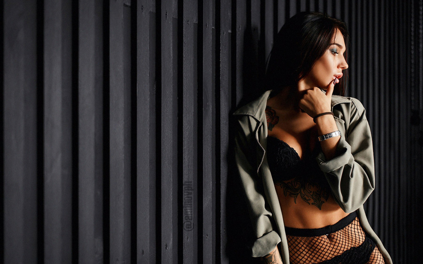 women, fishnet stockings, belly, black lingerie, pierced navel, finger on lips, painted nails, looking away, portrait