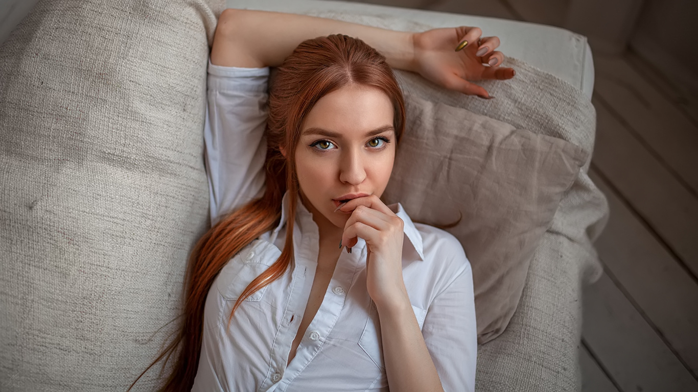 women, face, portrait, redhead, white shirt, finger on lips, painted nails, long hair, couch, top view