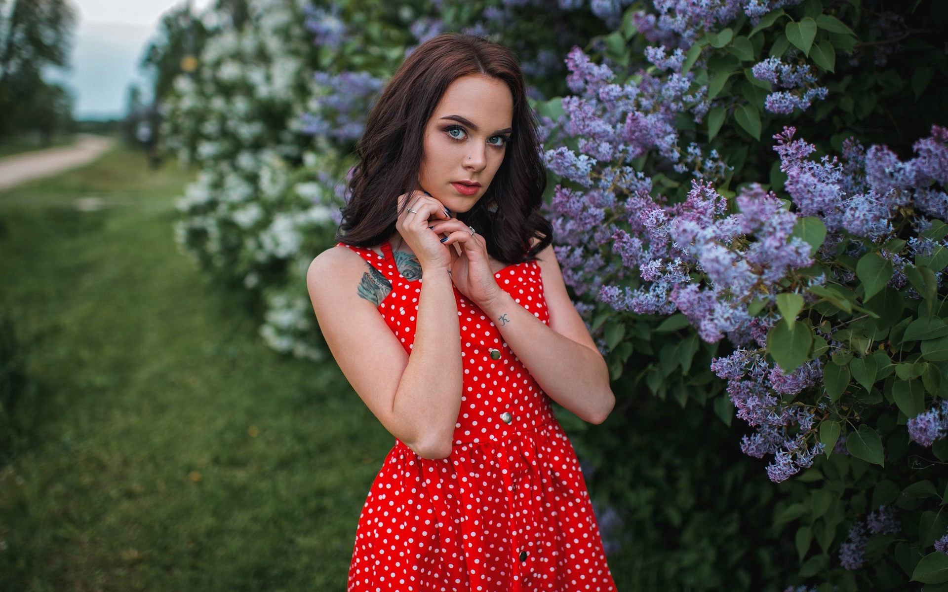 women, red dress, polka dots, women outdoors, tattoo, blue eyes, grass, blue nails, pierced nose, gray eyes, red lipstick, portrait, face