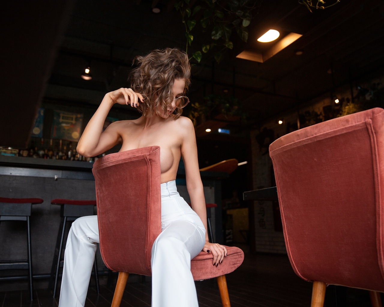 women, topless, boobs, women with glasses, pants, chair, sitting, brunette, painted nails, strategic covering