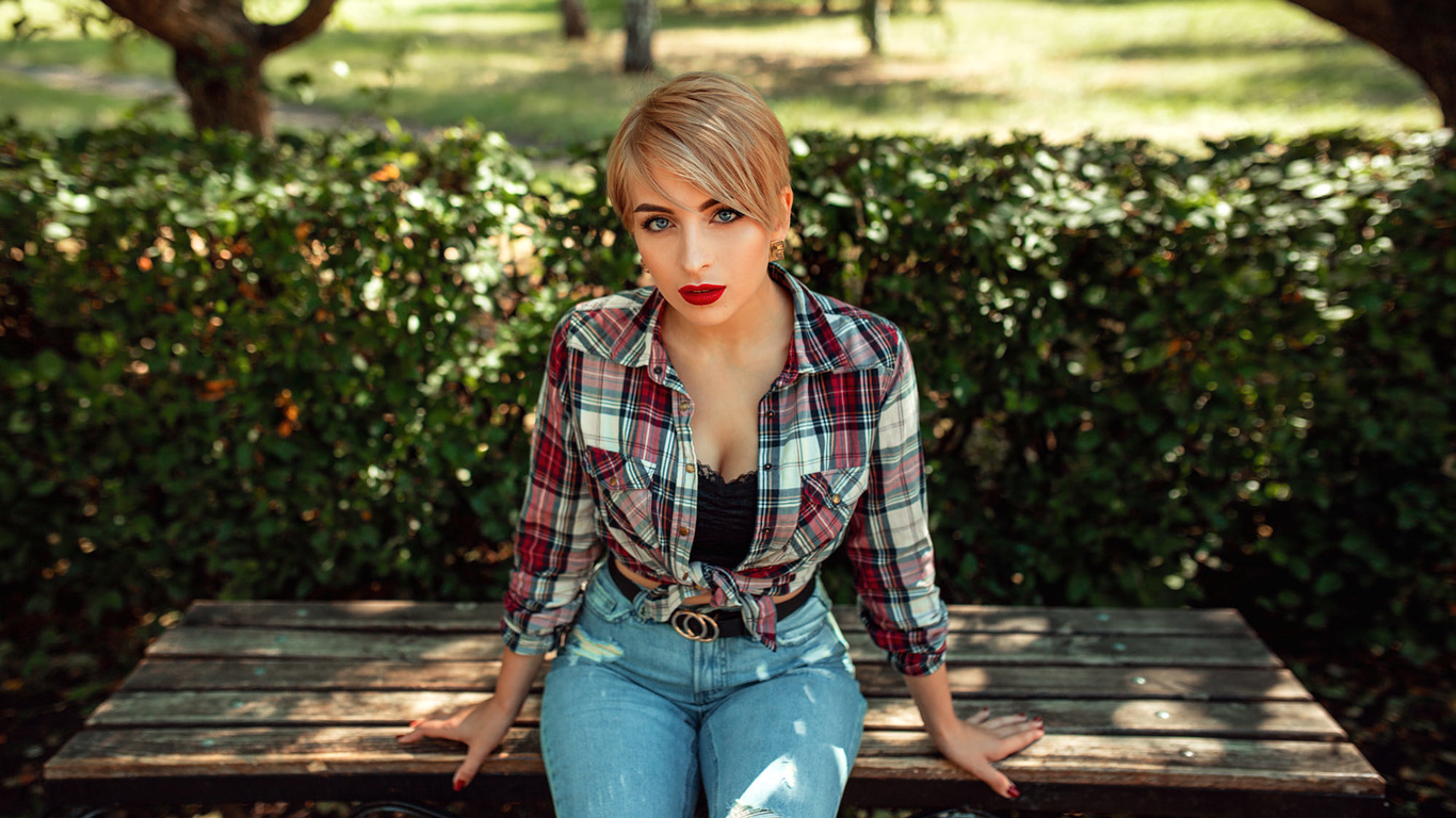 women, blonde, red lipstick, torn jeans, plaid shirt, trees, women outdoors, sitting, red nails, blue eyes, short hair, belt, bench, portrait