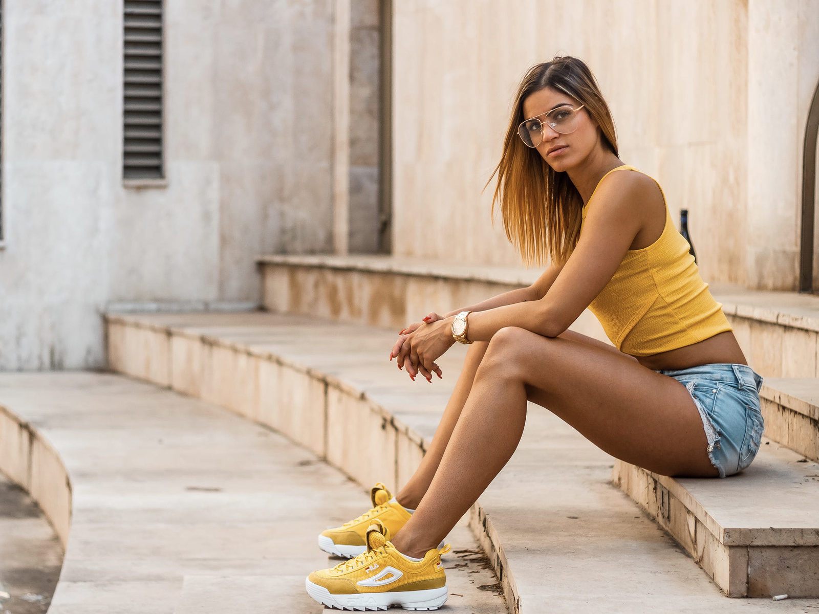 women, sitting, brunette, jean shorts, watch, red nails, tank top, women outdoors, women with glasses, sneakers