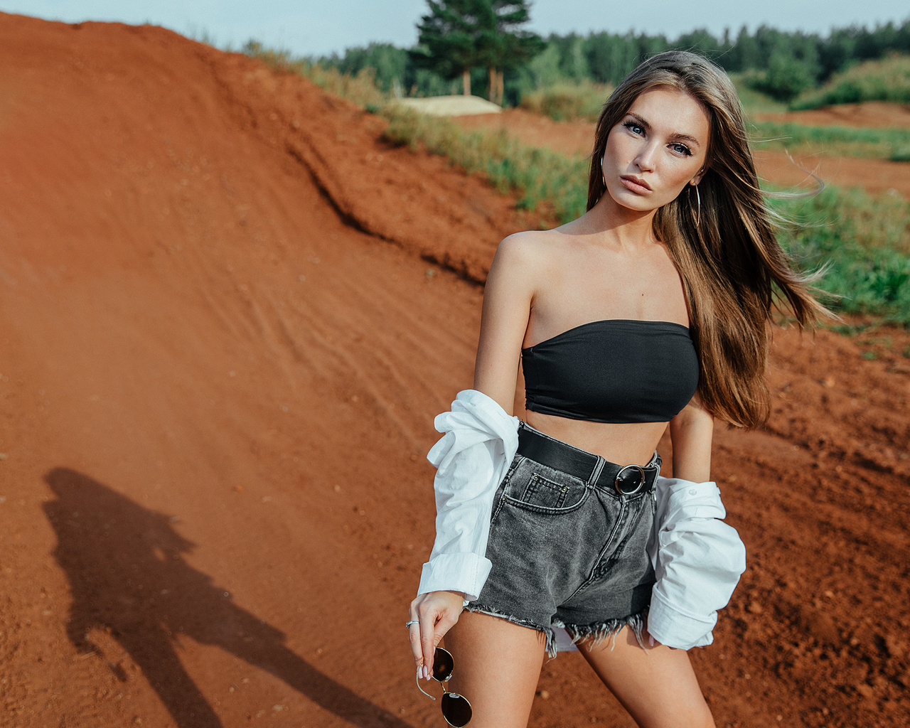 women, jean shorts, belt, women outdoors, skinny, sunglasses, long hair, white shirt, hoop earrings, bare shoulders, trees, brunette, short tops, black top