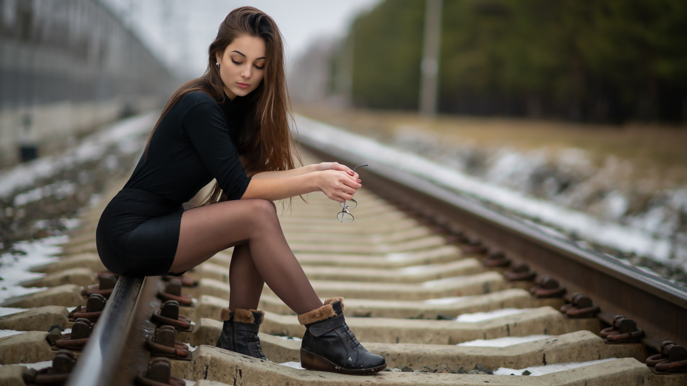 women, sitting, shoes, women outdoors, black clothing, long hair, railway, black skirts, glasses, 