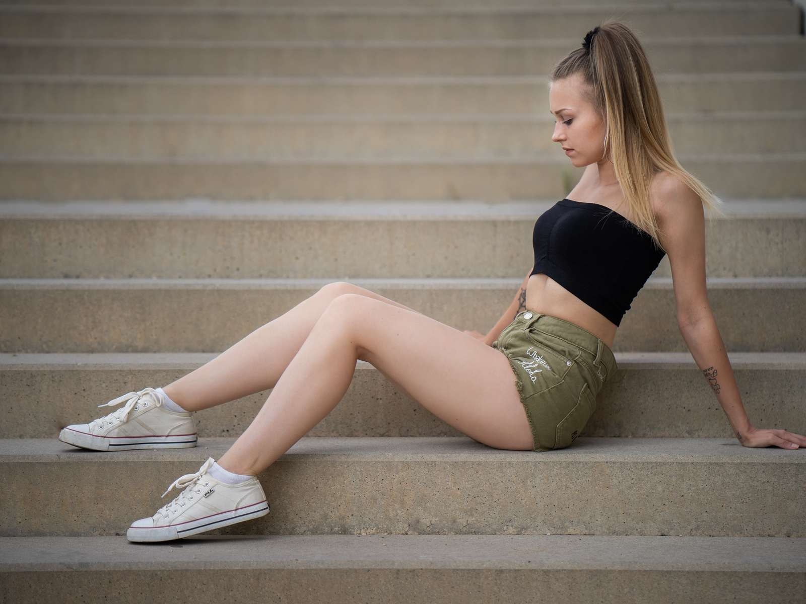 women, sitting, jean shorts, ponytail, stairs, blonde, white socks, sneakers, fila, tattoo, hoop earrings