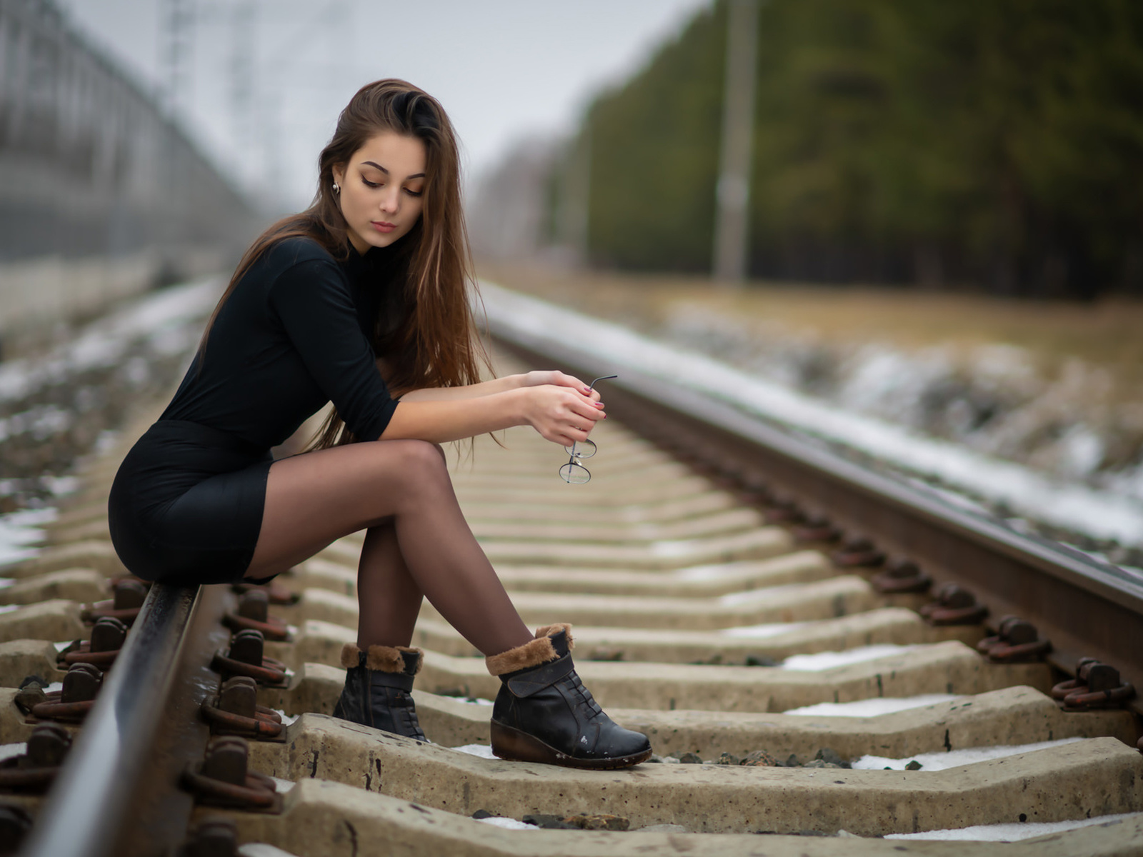 women, sitting, shoes, women outdoors, black clothing, long hair, railway, black skirts, glasses, 