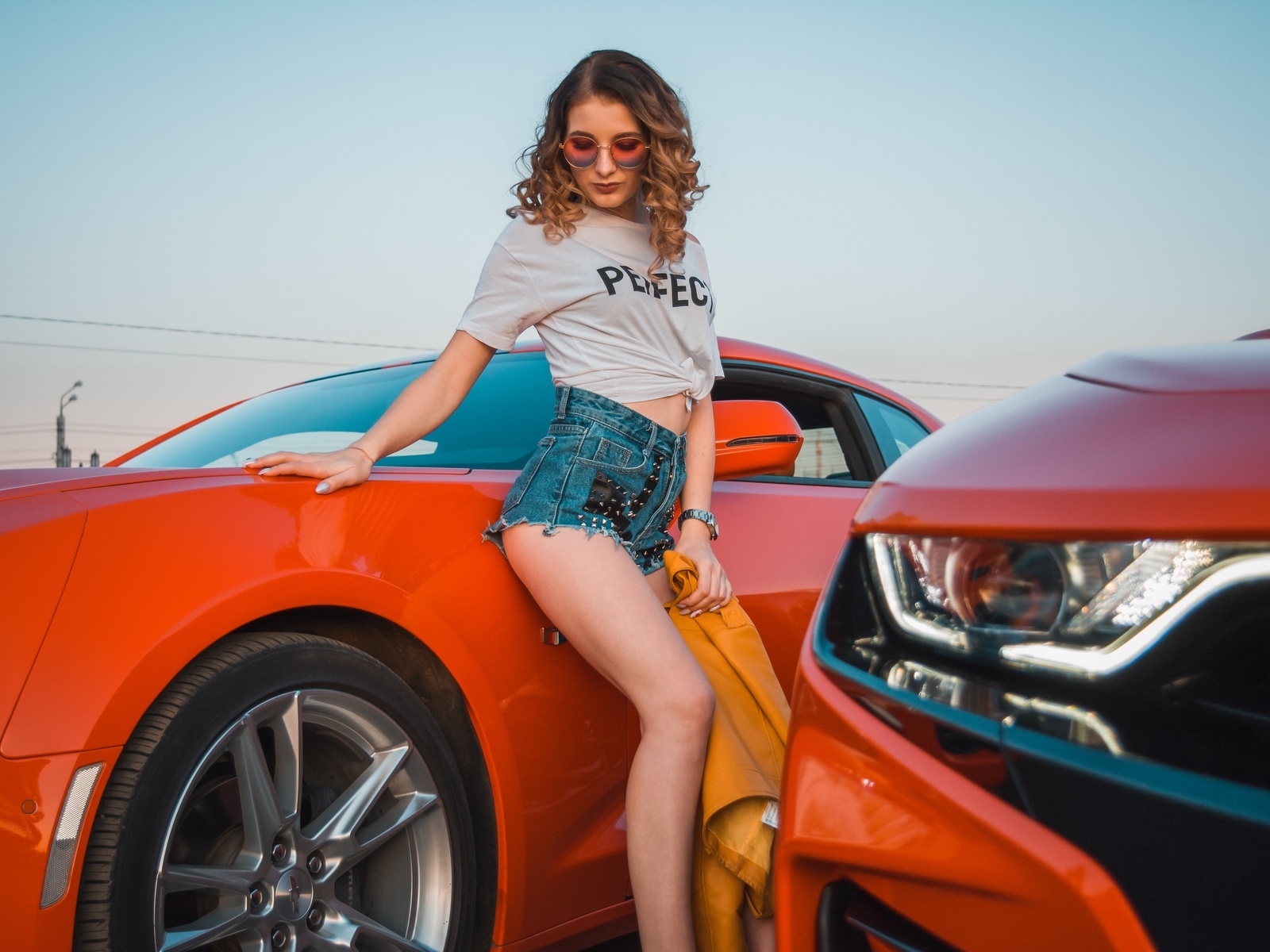 women, women with cars, jean shorts, white t-shirt, watch, women outdoors, curly hair, sky, chevrolet