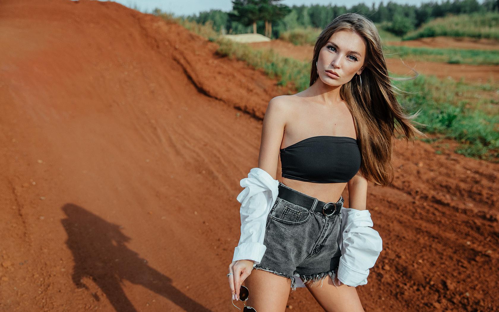 women, jean shorts, belt, women outdoors, skinny, sunglasses, long hair, white shirt, hoop earrings, bare shoulders, trees, brunette, short tops, black top