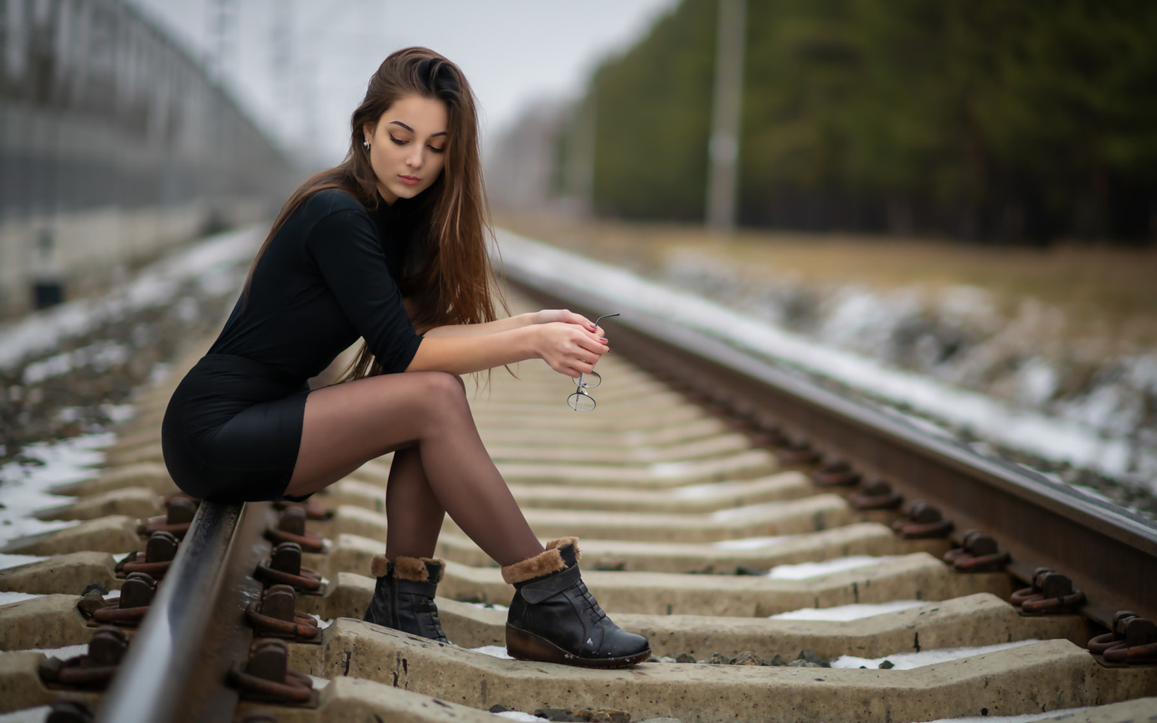 women, sitting, shoes, women outdoors, black clothing, long hair, railway, black skirts, glasses, 