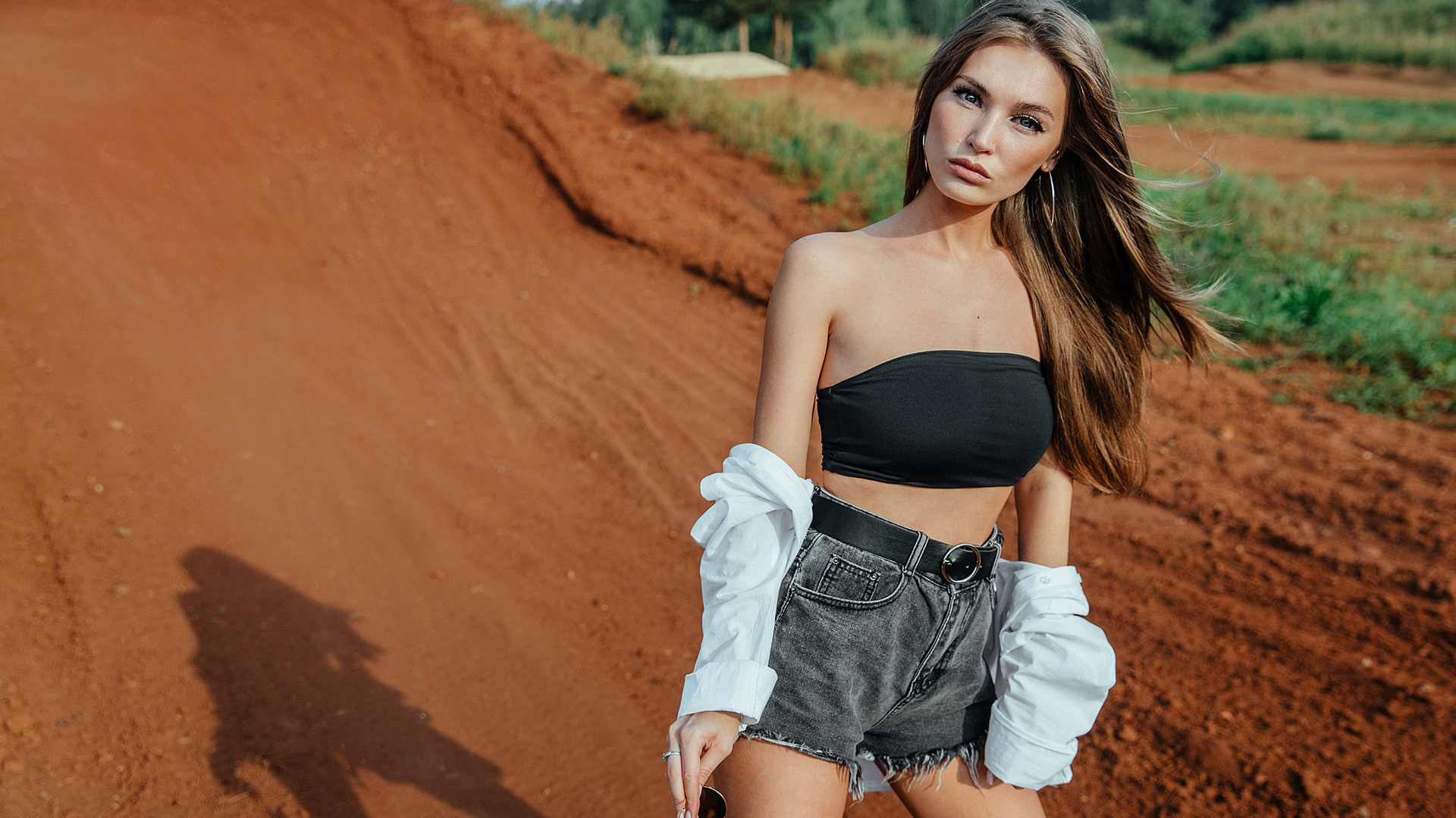 women, jean shorts, belt, women outdoors, skinny, sunglasses, long hair, white shirt, hoop earrings, bare shoulders, trees, brunette, short tops, black top