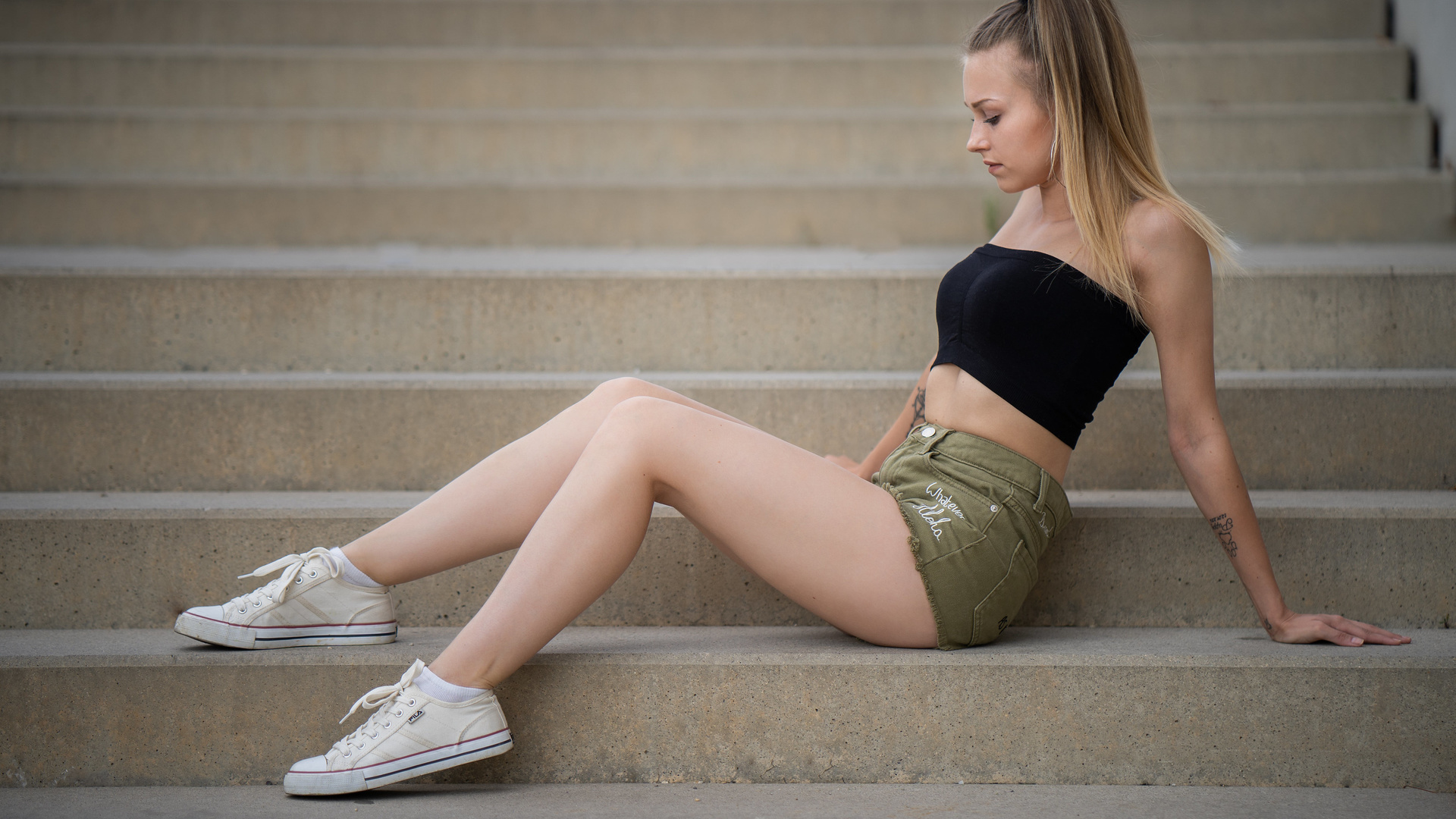 women, sitting, jean shorts, ponytail, stairs, blonde, white socks, sneakers, fila, tattoo, hoop earrings