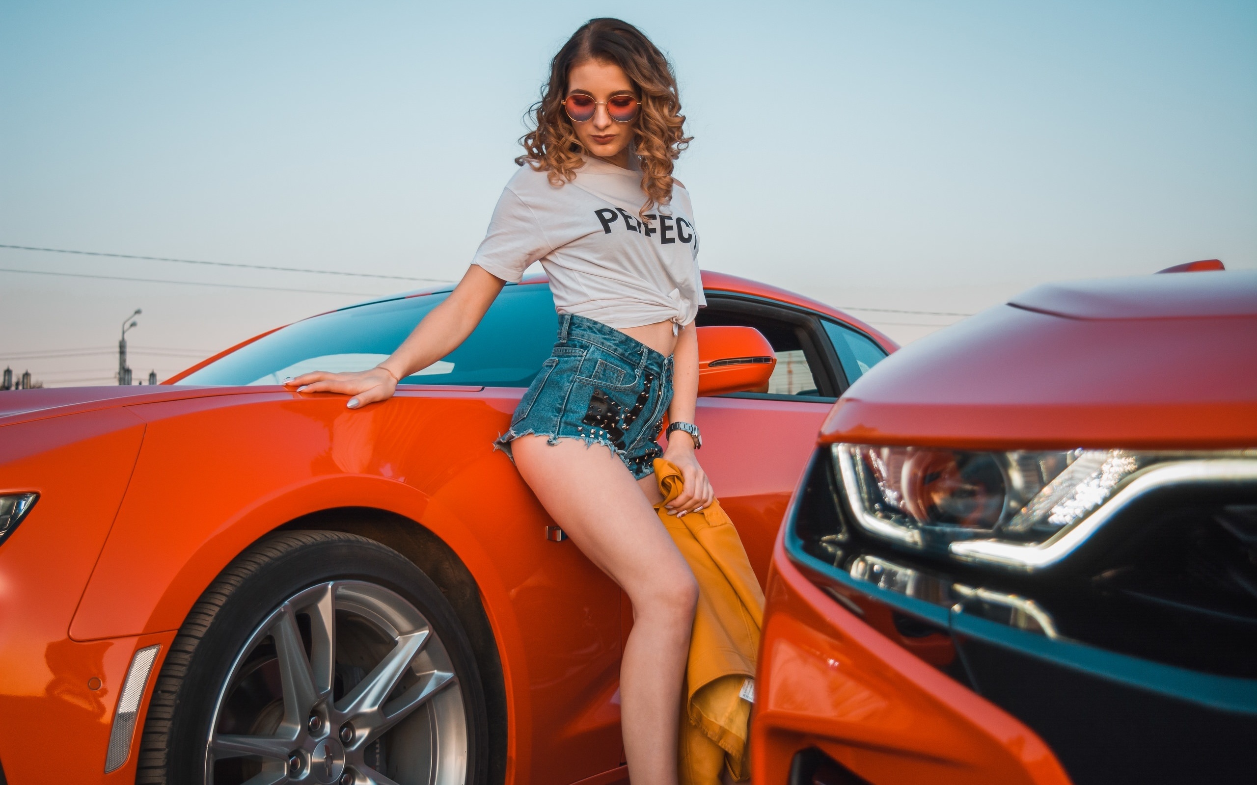 women, women with cars, jean shorts, white t-shirt, watch, women outdoors, curly hair, sky, chevrolet