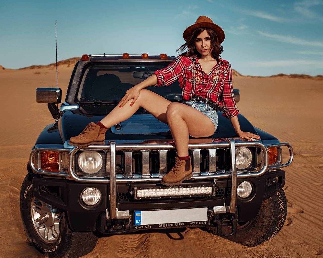 women, hat, women outdoors, sky, clouds, car, desert, plaid shirt, jean shorts, women with cars, shoes, red nails, socks, belt, sitting