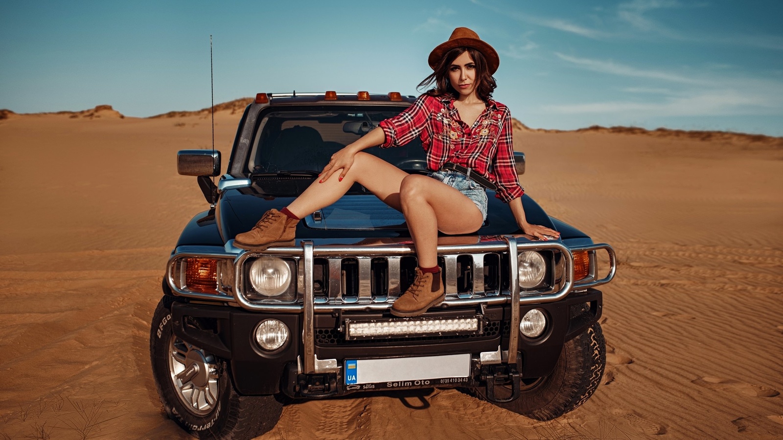 women, hat, women outdoors, sky, clouds, car, desert, plaid shirt, jean shorts, women with cars, shoes, red nails, socks, belt, sitting