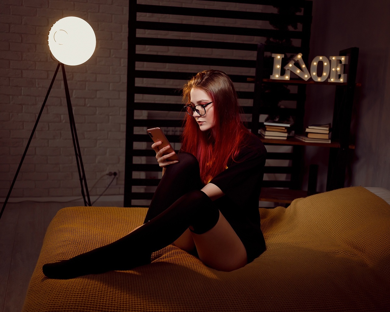 women, dyed hair, batman logo, in bed, black stockings, panties, sitting, glasses, wall, books, black t-shirt, cellphone, women with glasses