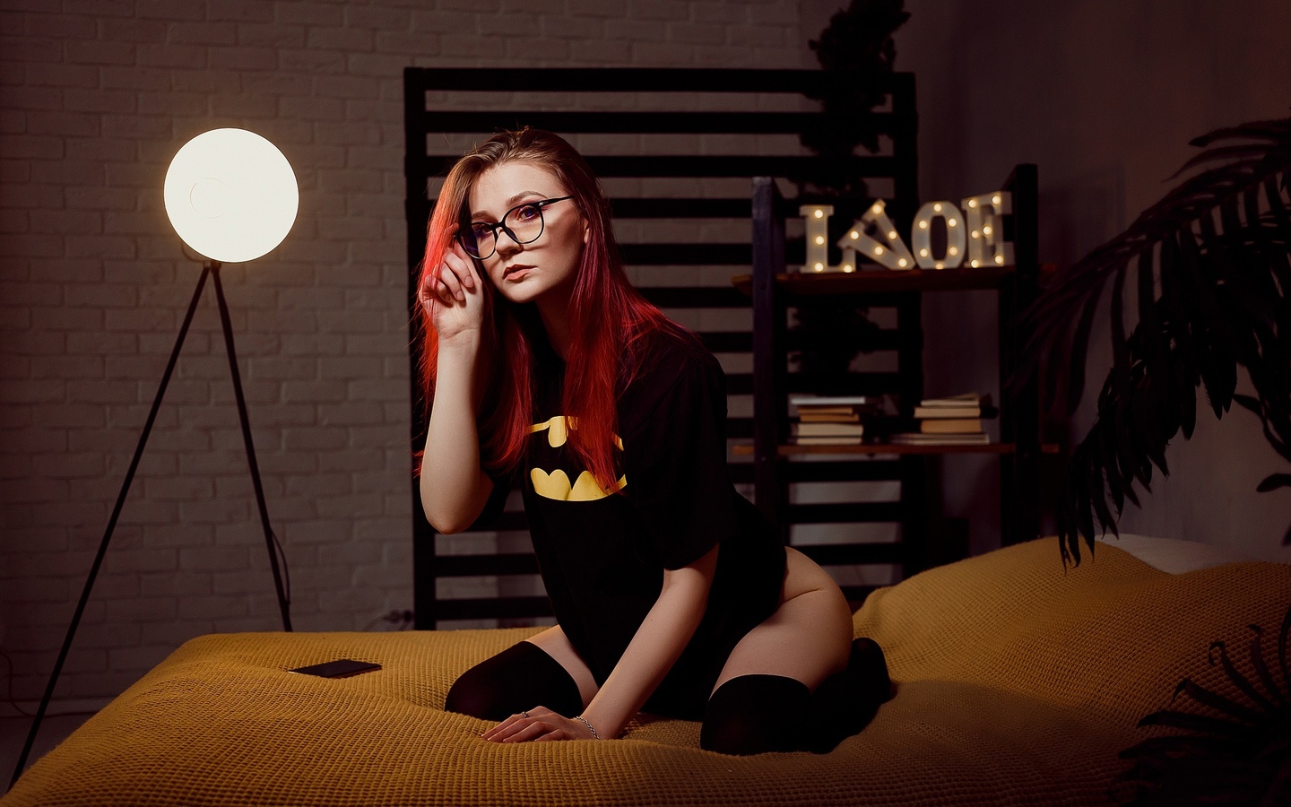 women, dyed hair, glasses, women indoors, kneeling, black stockings, in bed, plants, women with glasses, batman logo, black t-shirt, cellphone, wall, books