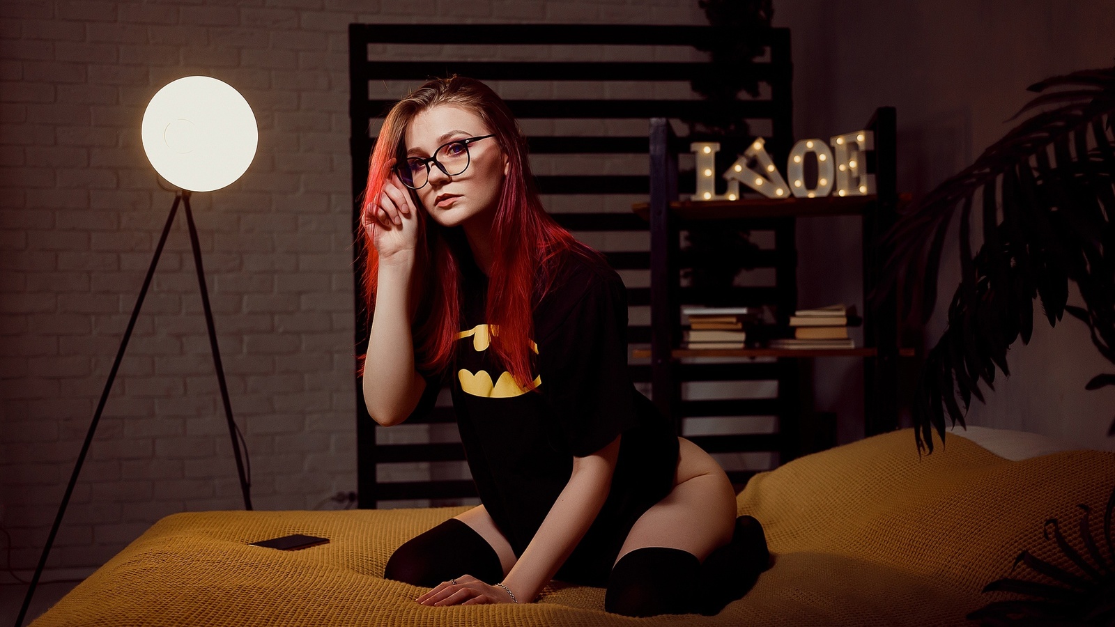 women, dyed hair, glasses, women indoors, kneeling, black stockings, in bed, plants, women with glasses, batman logo, black t-shirt, cellphone, wall, books