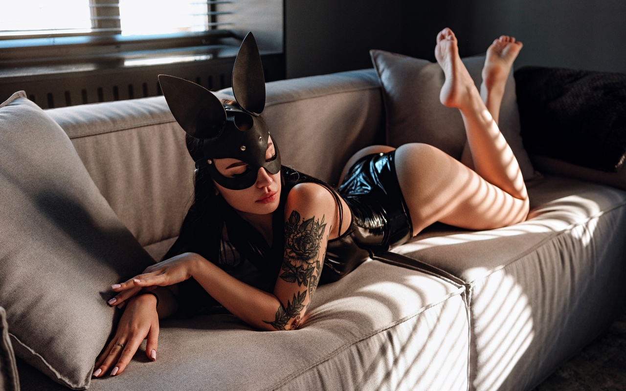 women, mask, black latex, women indoors, tattoo, ass, window, red lipstick, arched back, couch, blinds, feet in the air, bottom up, pink nails, bodysuit