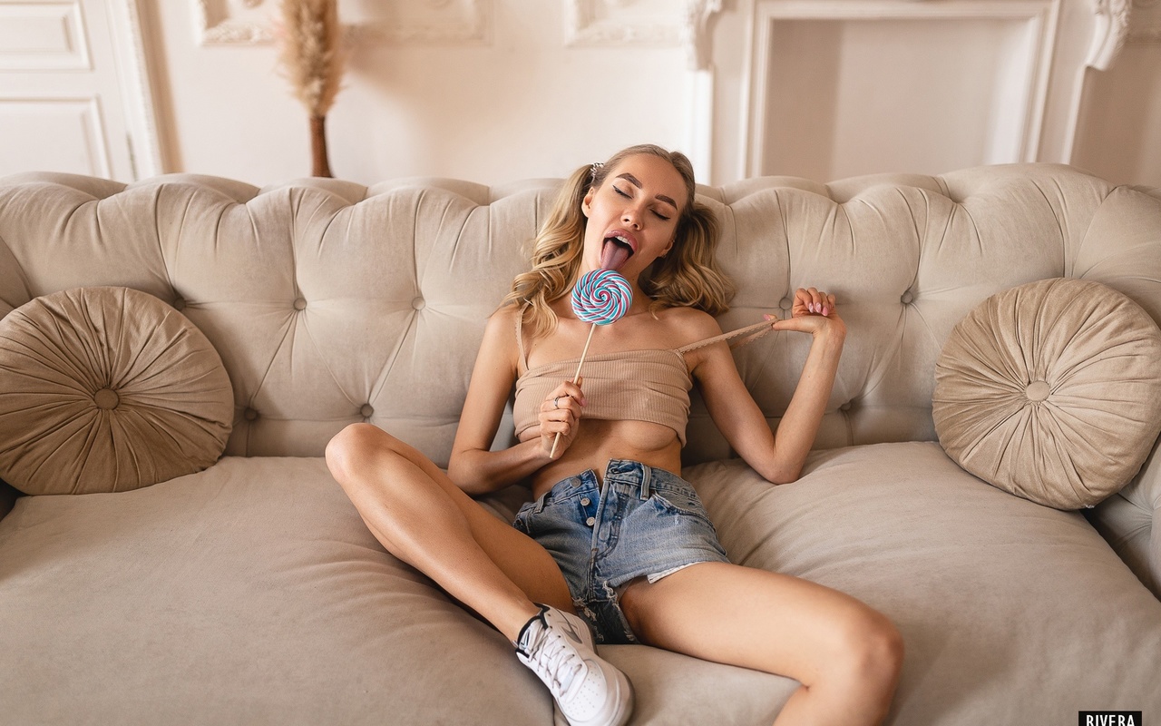 lesya madamskaya, women, ildar rivera, blonde, lollipop, jean shorts, pigtails, women indoors, closed eyes, sneakers, underboob, tongues, open mouth, couch, boobs, eyeliner, pink nails, sitting, nipples through clothing, skinny