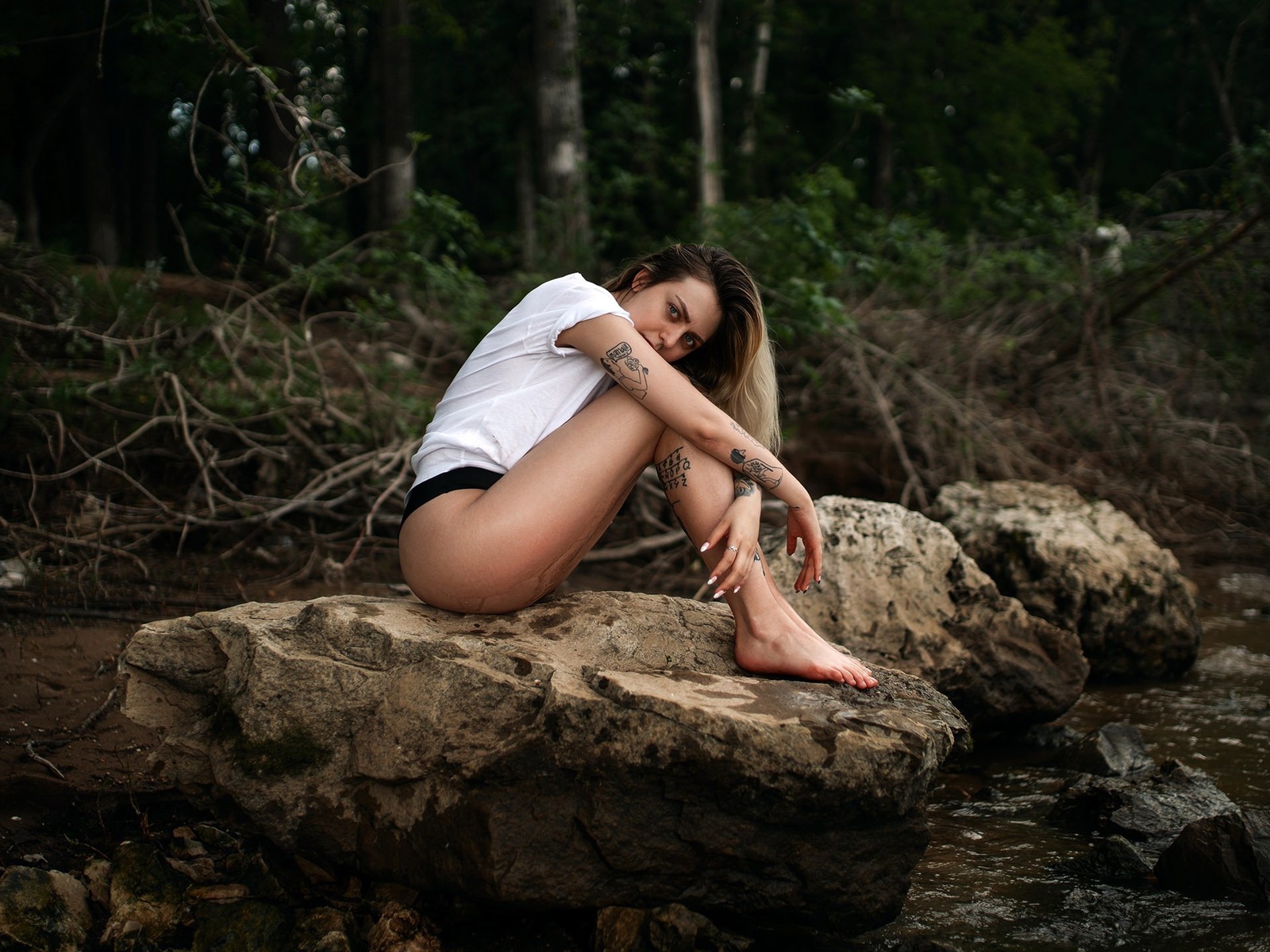 women, water, wet body, women outdoors, tattoo, sitting, brunette, white t-shirt, trees, nose ring, t-shirt, rocks, bikini bottoms