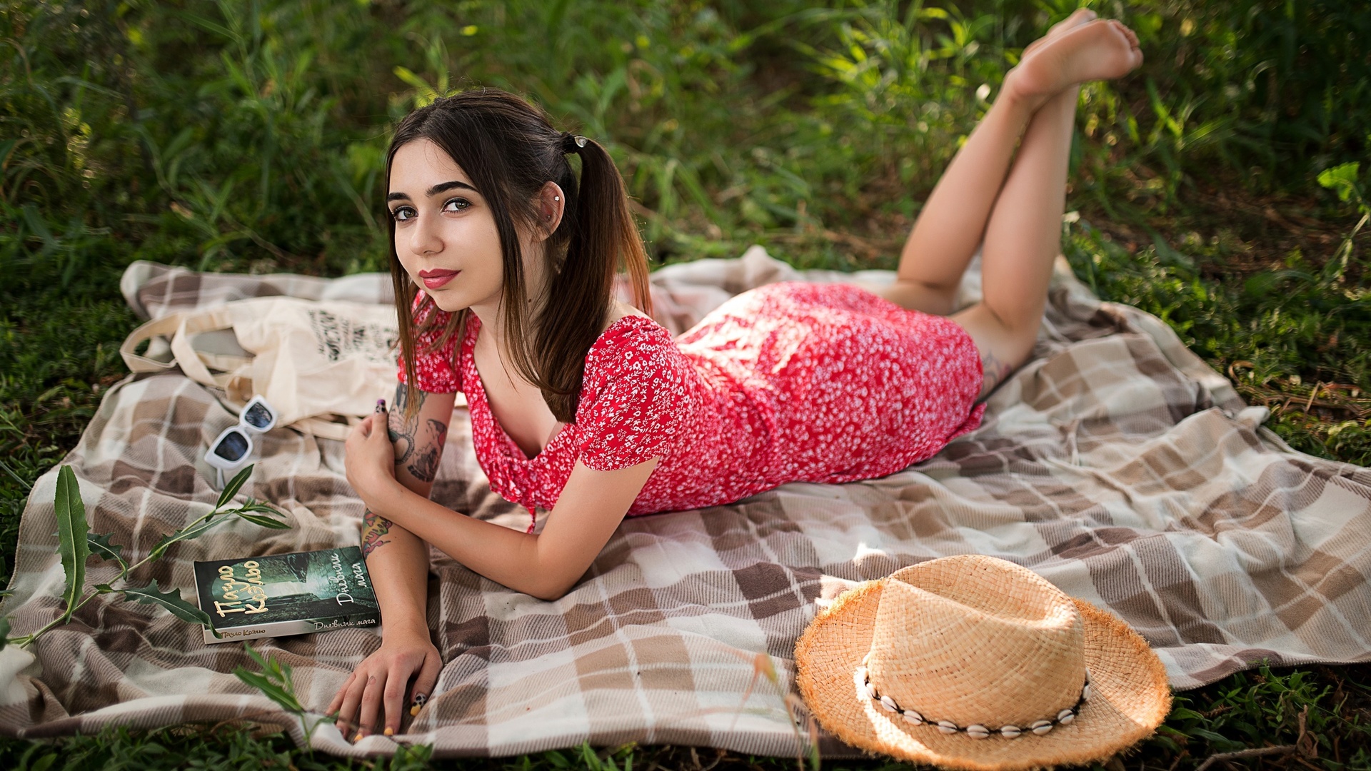 brunette, model, women, women outdoors, summer dress, tattoo, picnic, straw hat, sunglasses, glasses, lying on front, dress, barefoot, pierced ear, books, trees, grass, twintails