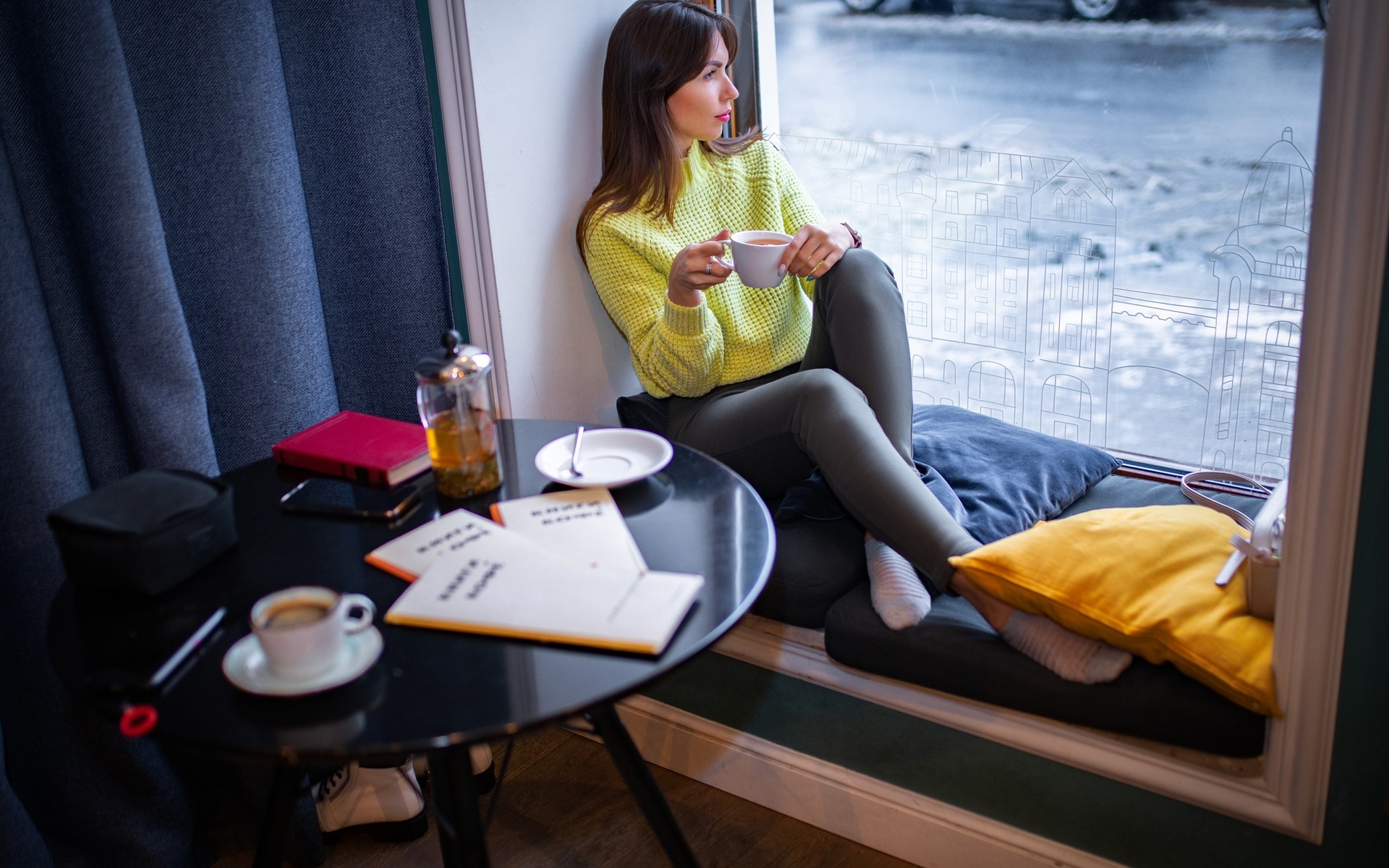 women, brunette, women indoors, model, sweater, yellow sweater, pants, black pants, window, by the window, looking at viewer, sitting, table, car, black car, coffee, looking out window