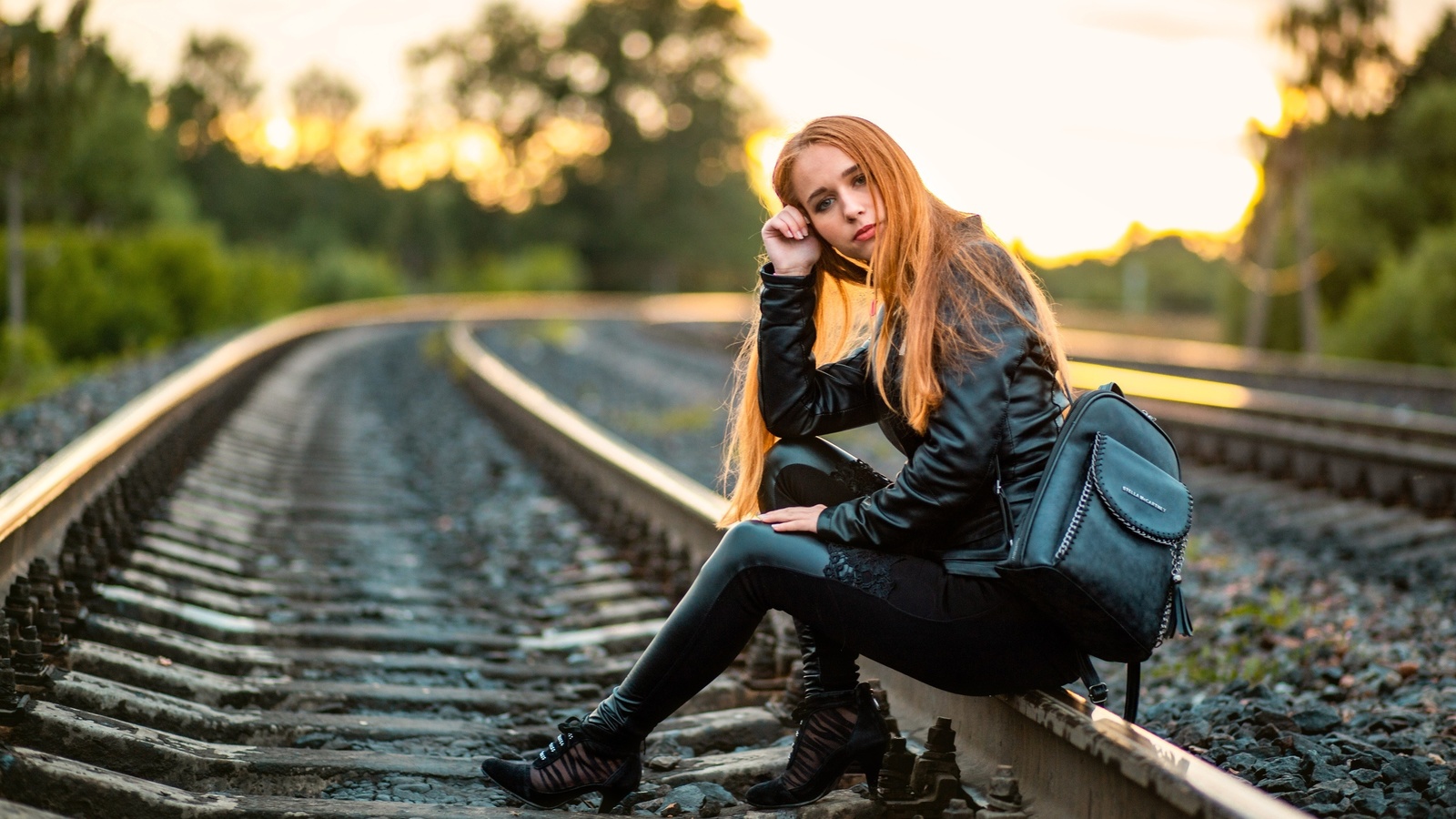 , railway, women, women outdoors, leather clothing, leather pants, leather jacket, trees, sky, backpack, redhead, nature, model, sitting, long hair