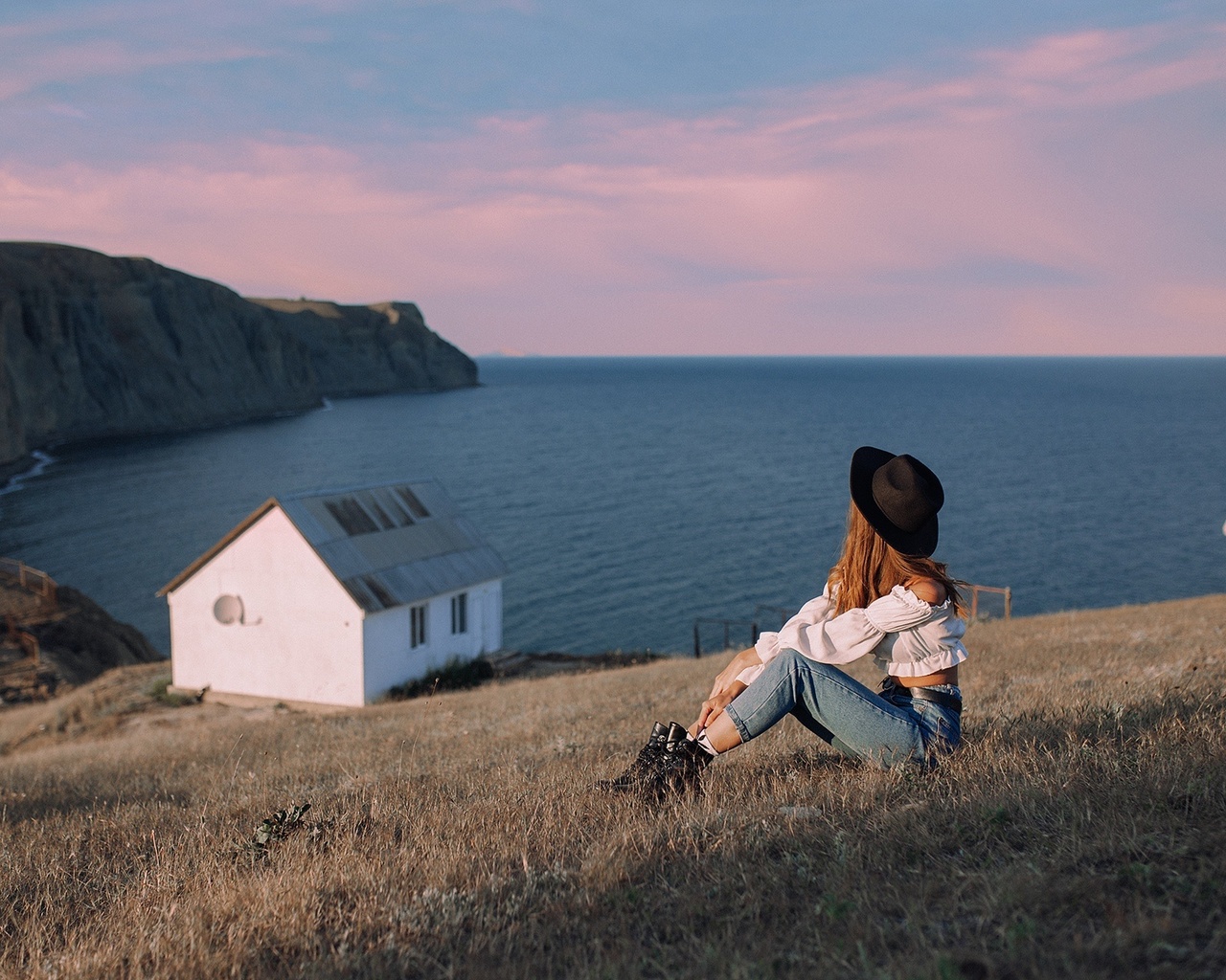 women outdoors, jeans, sea, , brunette, grass, nature, sky, model, clouds, black hat, cottage, boots, white blouse, white tops, white tops, landscape